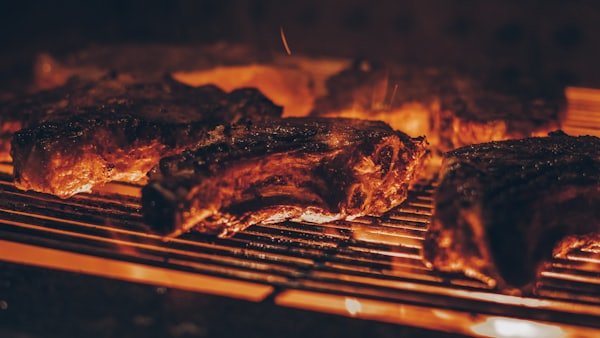 Carne haciéndose sobre la parrilla para la hamburguesa de la casa