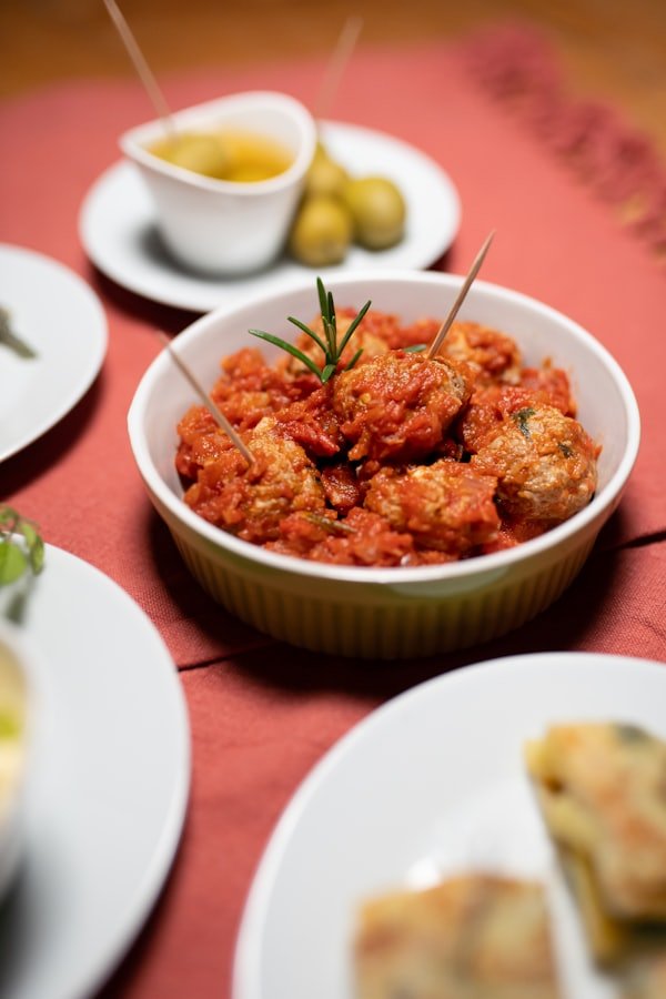 Tapa de pollo guisado servida en plato blanco